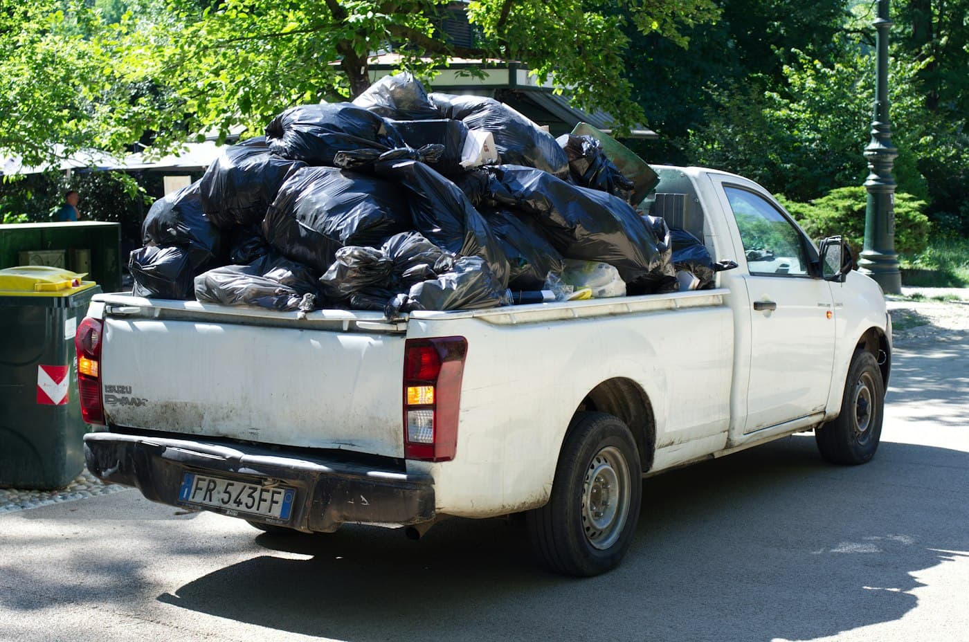 Pickup truck bed piled with black trash bags